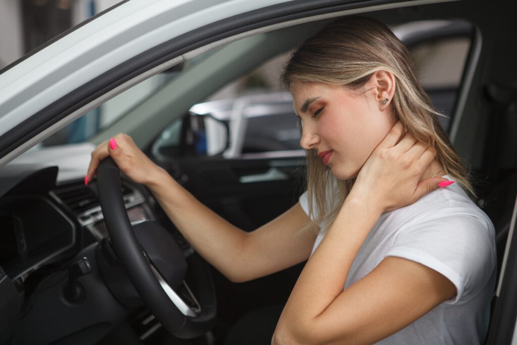 Woman clutching back of neck after accident